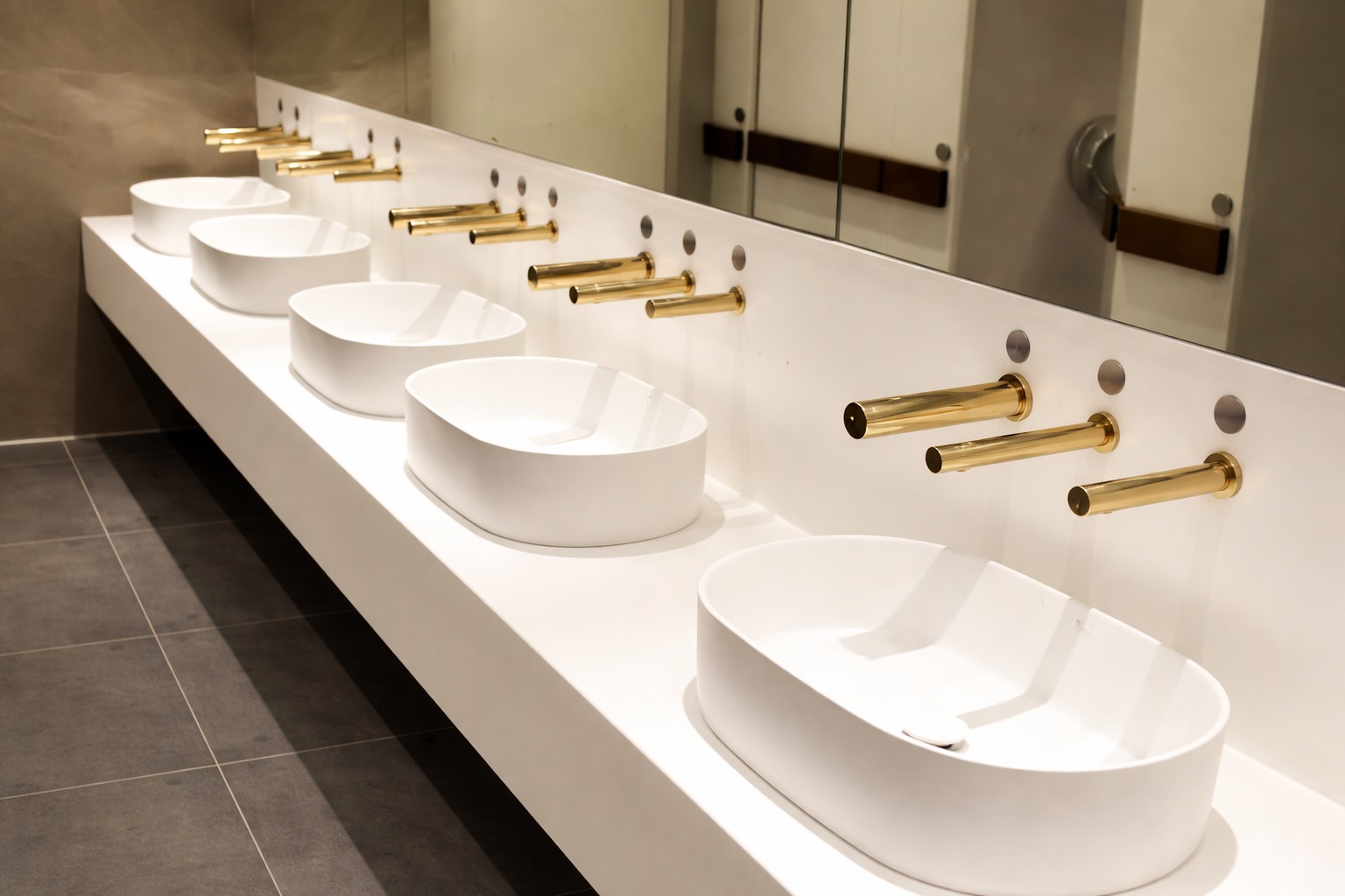 Commercial bathroom faucet manufacturers installed in airport concourse restroom